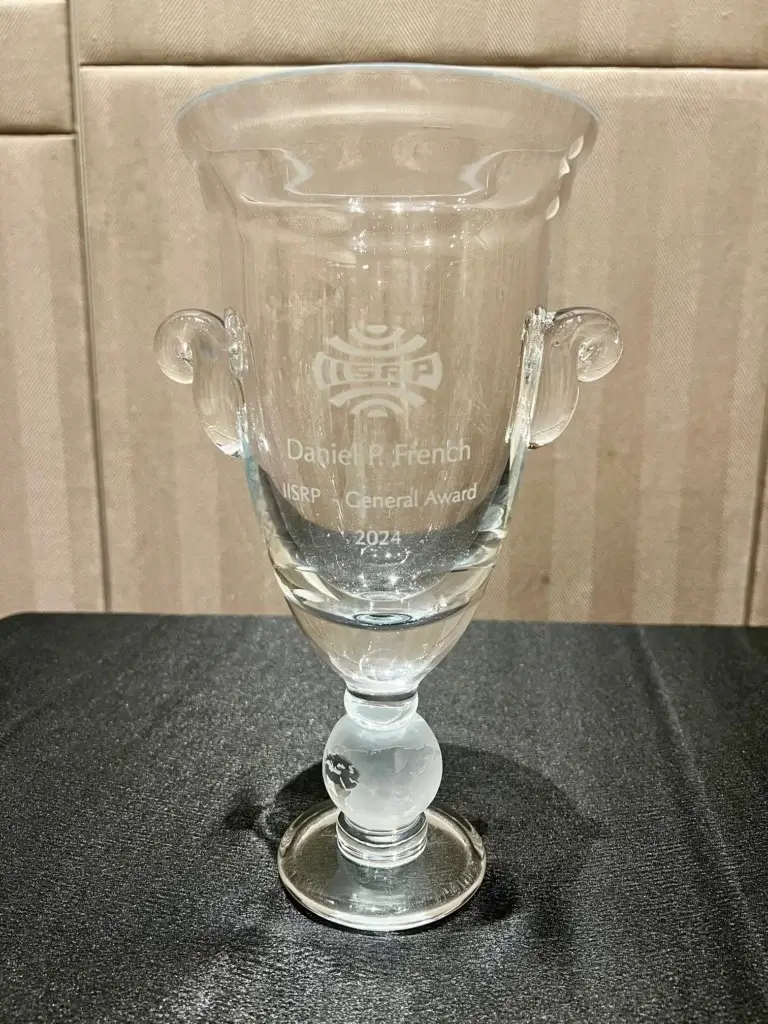 A glass vase etched with the logo of IISRP. Daniel P. French was honored with the IISRP General Award for Outstanding Contributions to the Synthetic Rubber Industry.