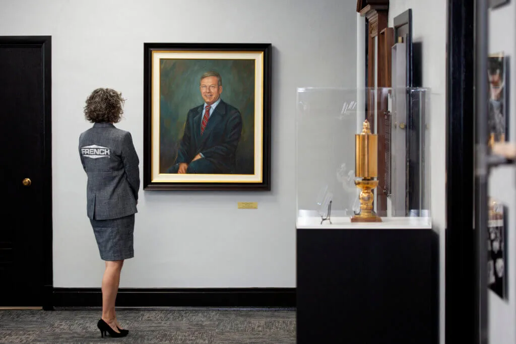 Tayte French Lutz looking at a painting of her Father Daniel French.