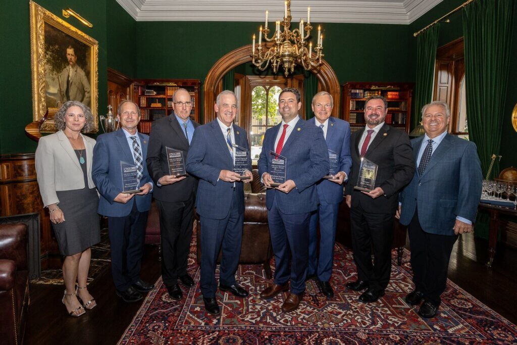 Group photo of 2024 Dan French Legacy Award recipients — including Senate President Rob McColley, House Speaker Matt Huffman, Senate President Pro-Tem Bill Reineke, Senator Brian Chavez, Representative Adam Holmes, and Representative Roy Klopfenstein — with OMA Board Chair Jeff Oravitz and Tayte French Lutz presenting the awards.