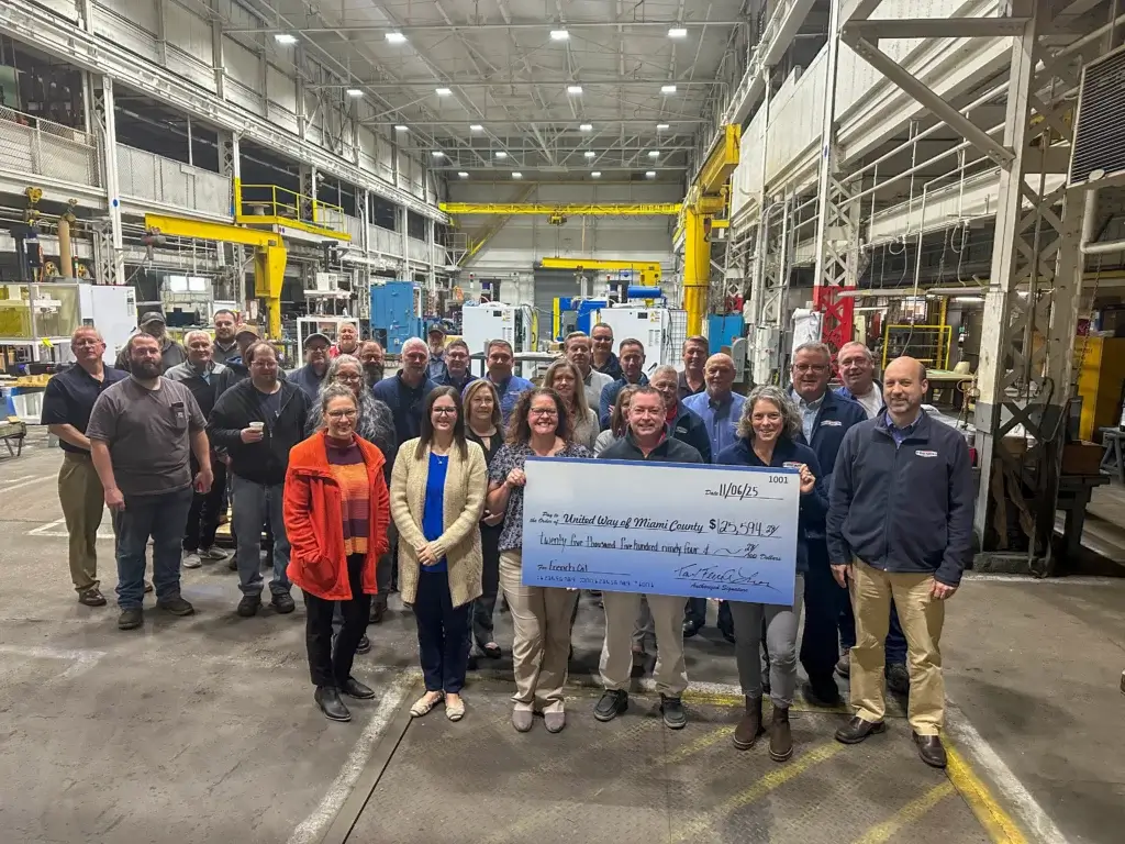 A photo of French employees with a large check for the United Way.